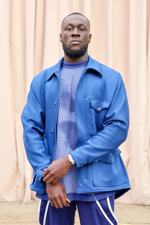 Stormzy posing in a light blue leather jacket, a blue shirt and blue pants at the the Burberry Sprin...
