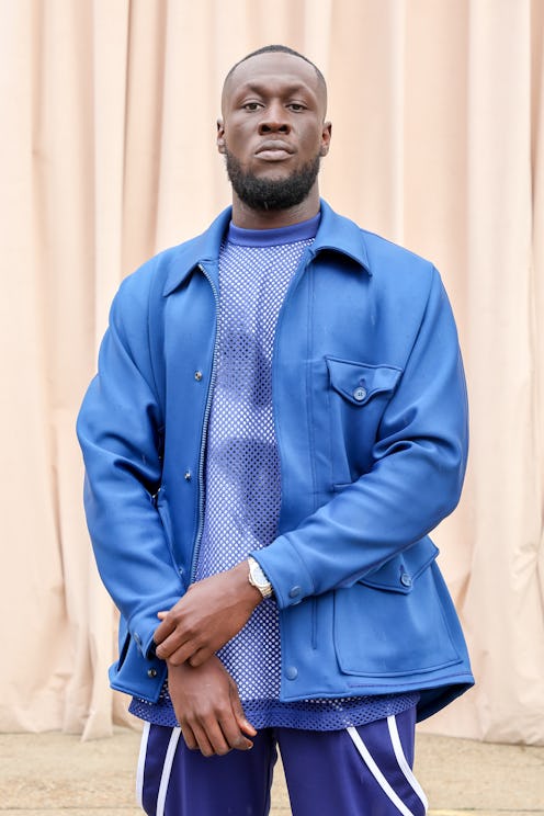 Stormzy posing in a light blue leather jacket, a blue shirt and blue pants at the the Burberry Sprin...