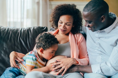Mixed race family waiting for the new baby, in an article about what amniotic fluid is. 
