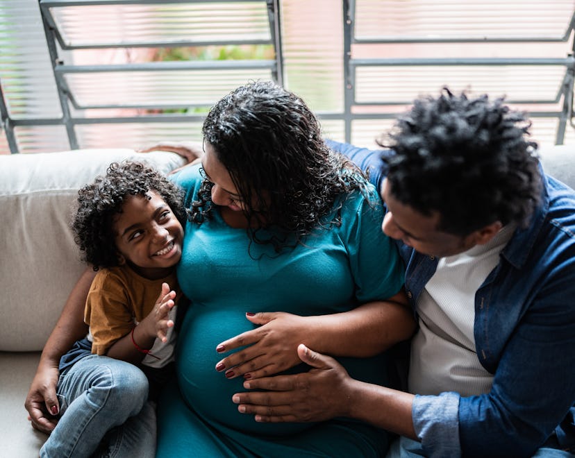 Father and pregnant mother with son at home