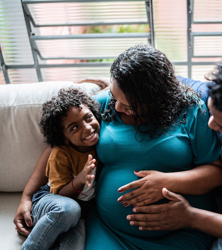 Father and pregnant mother with son at home