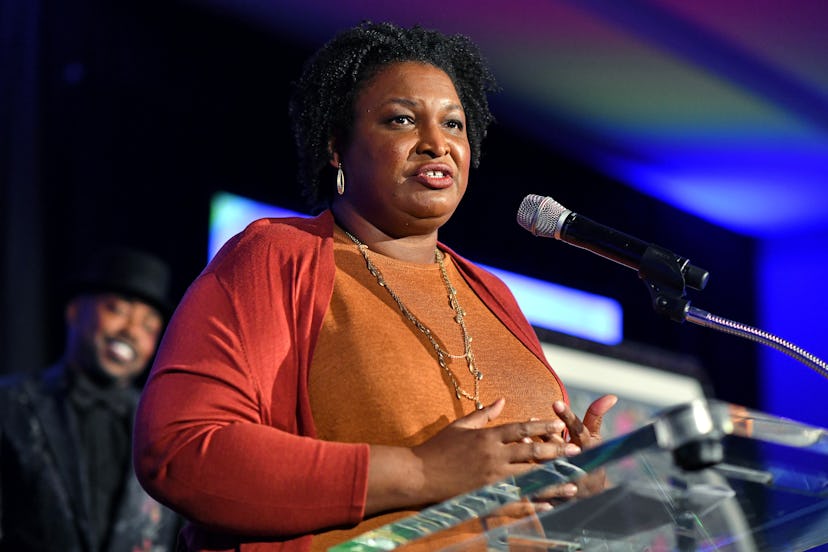 Stacey Abrams during her speech in an orange shirt and sweater combination