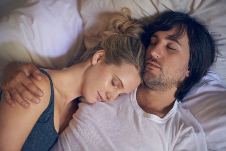 A man and woman sleeping in bed.