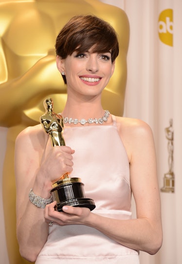 Anne Hathaway poses in the press room during the Oscars.