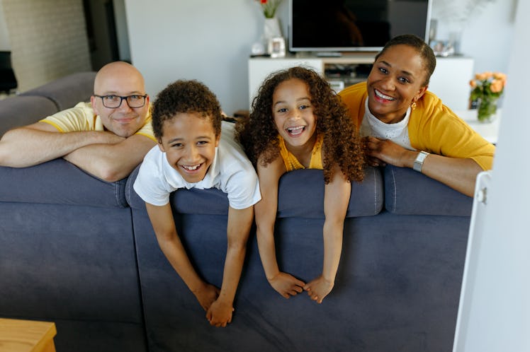 A family of four sitting on a couch.