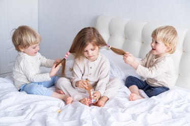 两兄弟玩姐姐的长发,坐在床万博体育app安卓版下载上。