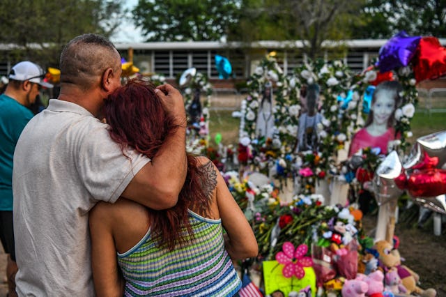 People pay tribute and mourn at a makeshift memorial for the victims of the Robb Elementary School s...