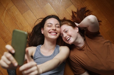Two young girls smiling and posing for a selfie.