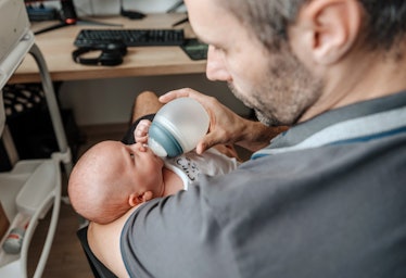 A dad feeding his baby a bottle.