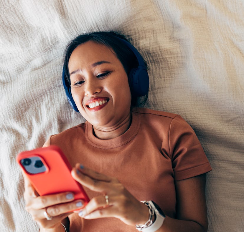 Gen Z woman sending a cute "good morning" text in bed.