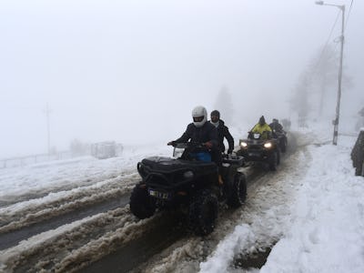 GULMARG, INDIA - OCTOBER 20: Tourists ride a snow scooter after a fresh spell of snow on October 20,...