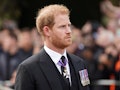 The Duke of Sussex follows the coffin of Queen Elizabeth II, draped in the Royal Standard with the I...