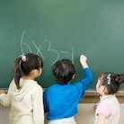 Three children working on a math problem on a chalk board. A new study by the National Center for Ed...