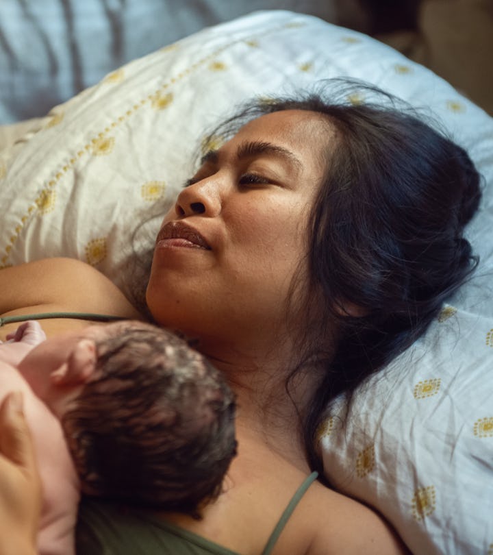 A woman who just experienced a home birth holds her just born baby in an article about birth plan ch...