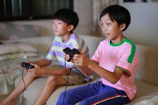 Boys playing video game at home. Researchers found that compared with children who never played vide...