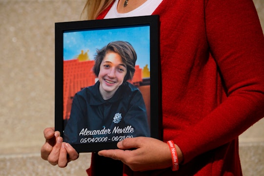Amy Neville stands for a portrait with a picture of her son Alexander Neville, who died in June 2020...