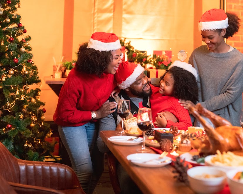 Family having Christmas dinner at home, gathered around the table, enjoying their time together, dau...