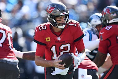 CHARLOTTE, NORTH CAROLINA - OCTOBER 23: Tom Brady #12 of the Tampa Bay Buccaneers fakes a handoff in...