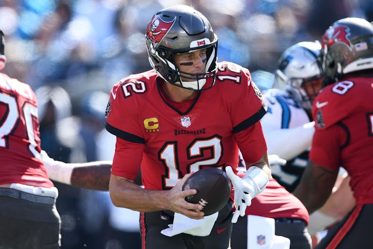 CHARLOTTE, NORTH CAROLINA - OCTOBER 23: Tom Brady #12 of the Tampa Bay Buccaneers fakes a handoff in...