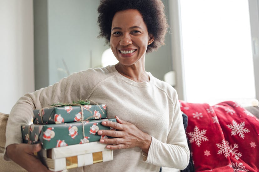 Shot of a woman holding Xmas presents and smiling