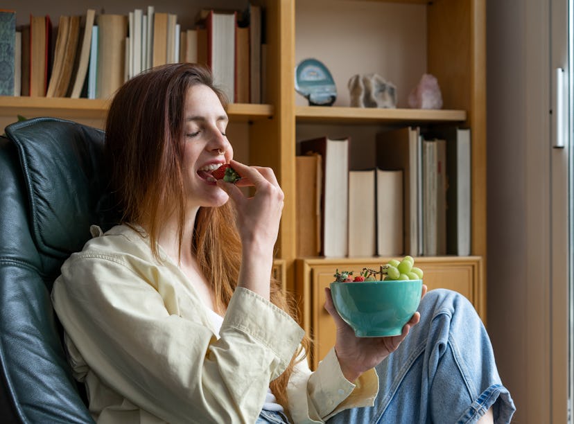 A woman enjoys a bowl of grapes after learning how to make candy grapes from TikTok. 