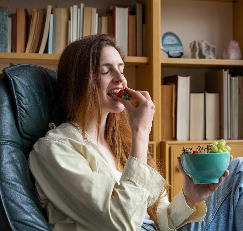A woman enjoys a bowl of grapes after learning how to make candy grapes from TikTok.