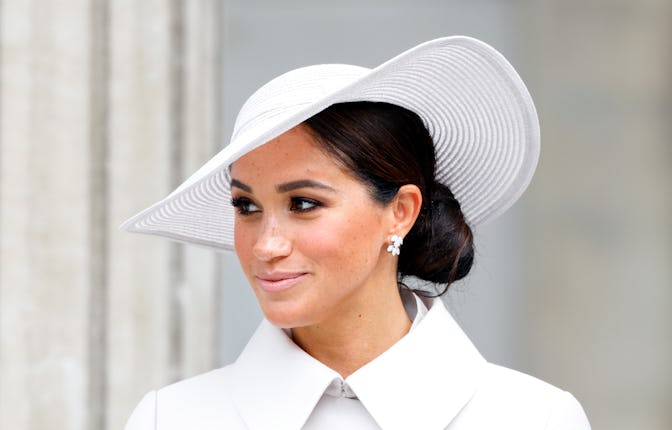 Meghan Markle in a white jacket and white sunhat, wearing her hair in a low bun at the Platinum Jubi...