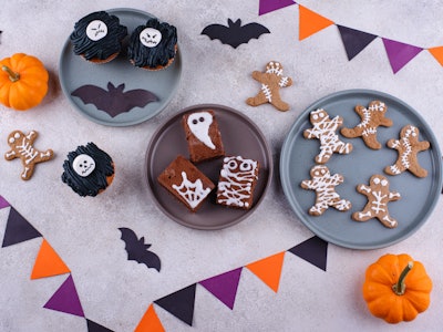 Set of scary Halloween desserts. Mummy cookies, monster cupcakes and ghost brownie