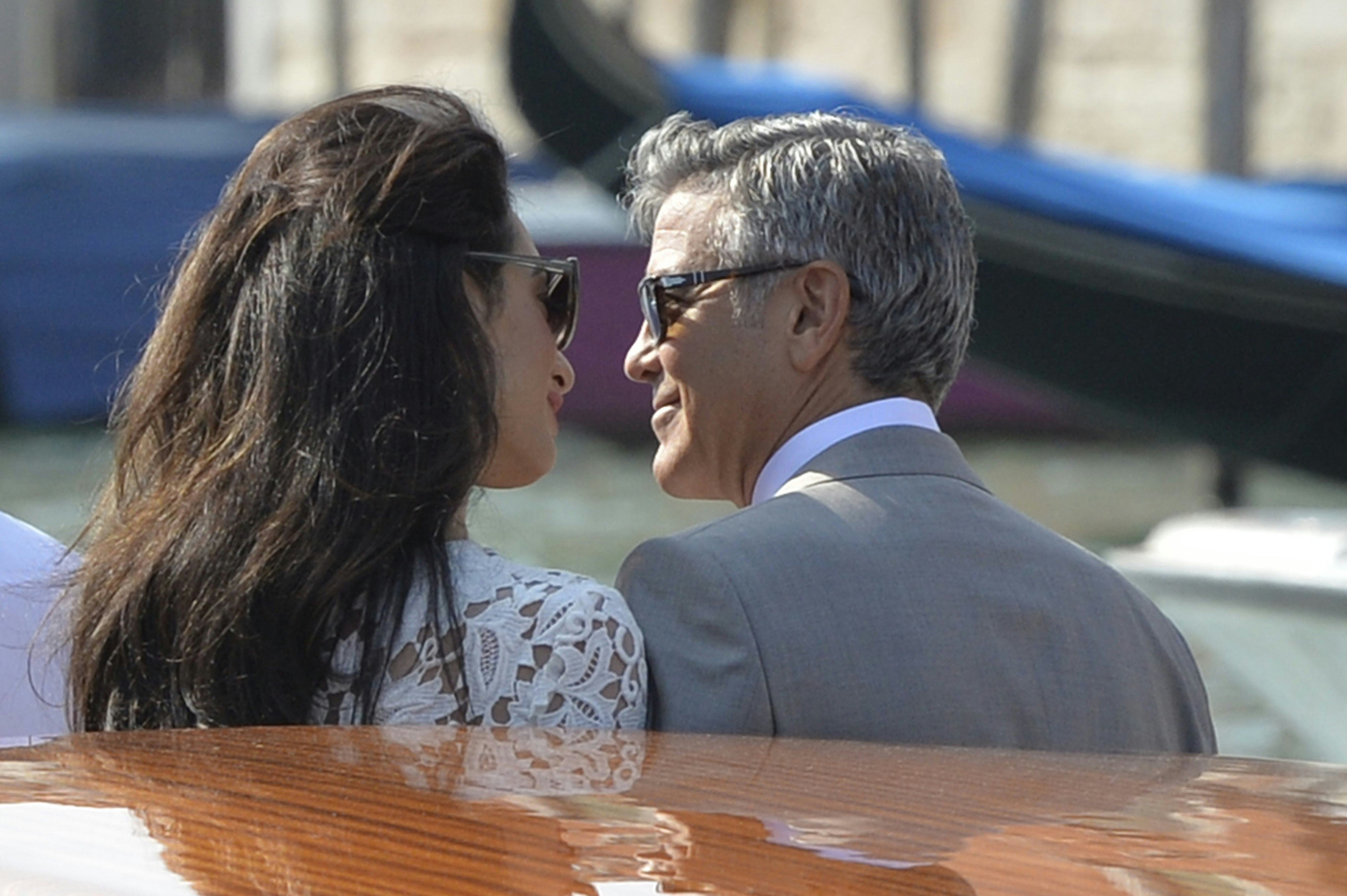 US actor George Clooney (R) and his wife Amal Alamuddin stand on a taxi boat on the Grand Canal on S&hellip;