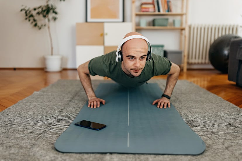 Man doing push-ups at home on yoga mat.