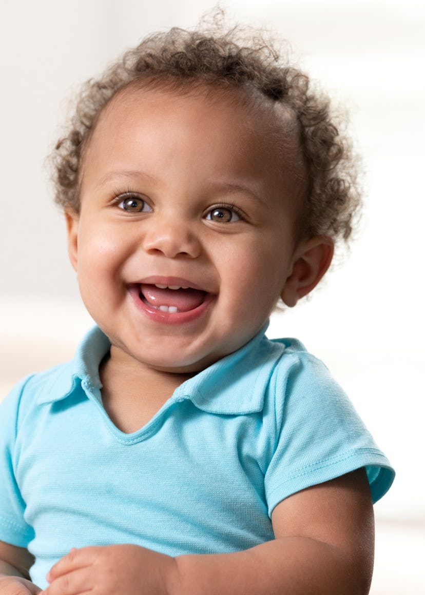 Smiling curly haired toddler in article about I names for baby boys