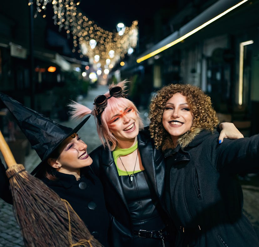 Three friends wearing all-black halloween costumes.