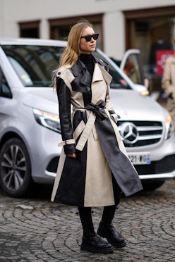 Woman wearing two-toned black and white belted non-traditional trench coat.