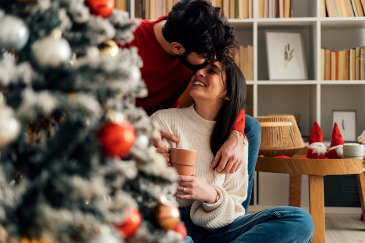 Man kissing woman’s forehead after receiving a sexy Christmas text 