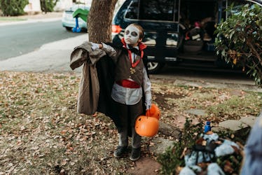 一个小男孩打扮成吸血鬼,手里拿着一个枕套,这就是“不给糖就捣蛋”