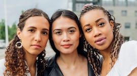 Three women pose with a serious expression as they consider how the November 2022 full moon lunar ec...