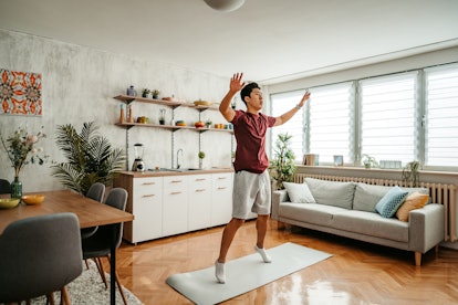 一个男人在家里做开合跳练习。