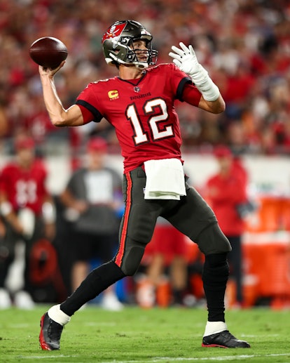 Tom Brady wearing his Tampa Bay Buccaneers #12 jersey throwing a pass against the Baltimore Ravens