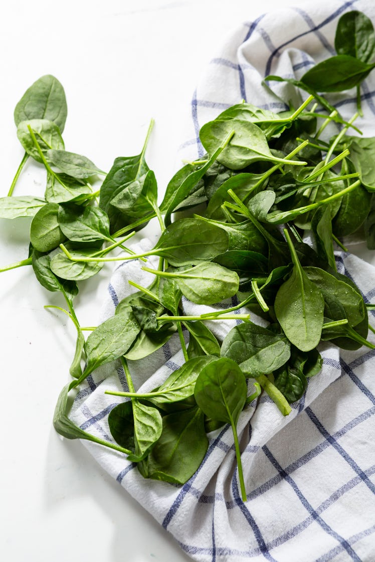 Organic spinach baby leaves on kitchen towel, healthy food