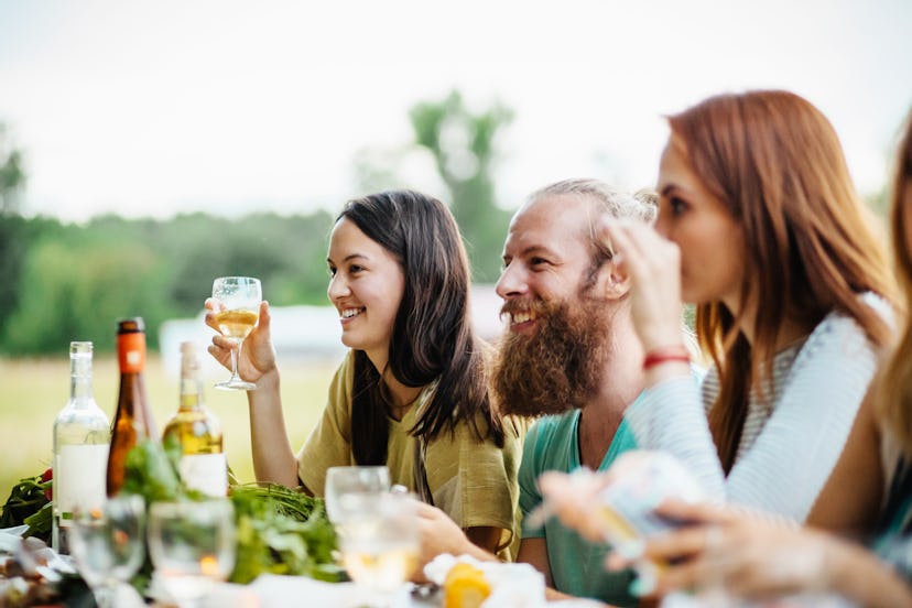 A group of friends smiling, chatting  on Friendsgiving.