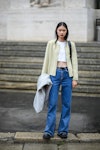 Wearing fall 2022 fashion trends for blue auras, a guest wears a white cropped top, a white latte ja...