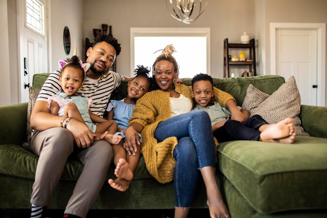 Family of five playing on sofa at home