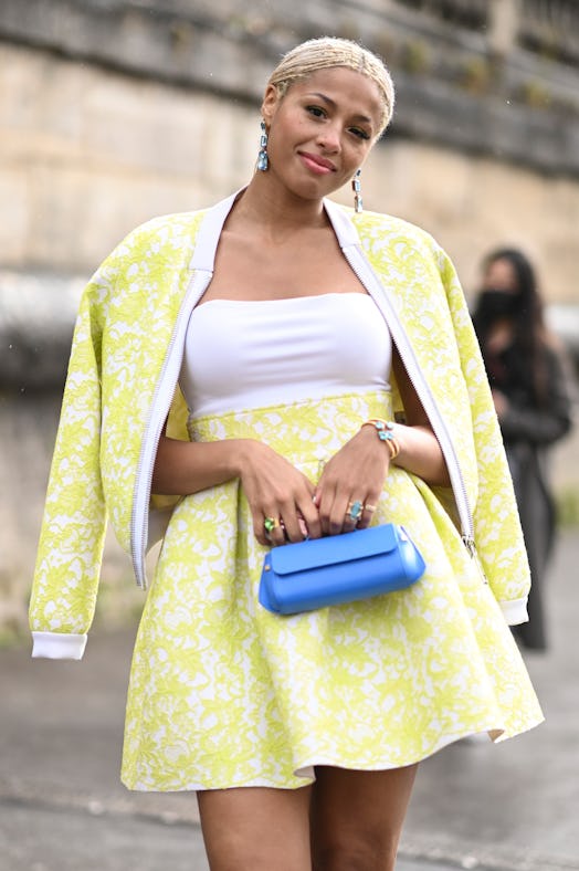 PARIS, FRANCE - SEPTEMBER 27: A guest is seen wearing a lime green floral jacket and skirt with baby...