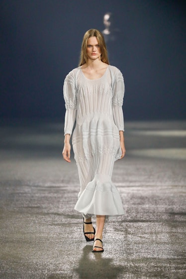A model in Issey Miyake maxi light gray dress at Paris Fashion Week Spring 2023.
