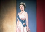 Queen Elizabeth II wearing the crown jewels, dressed for a formal occasion. She wears her family's o...