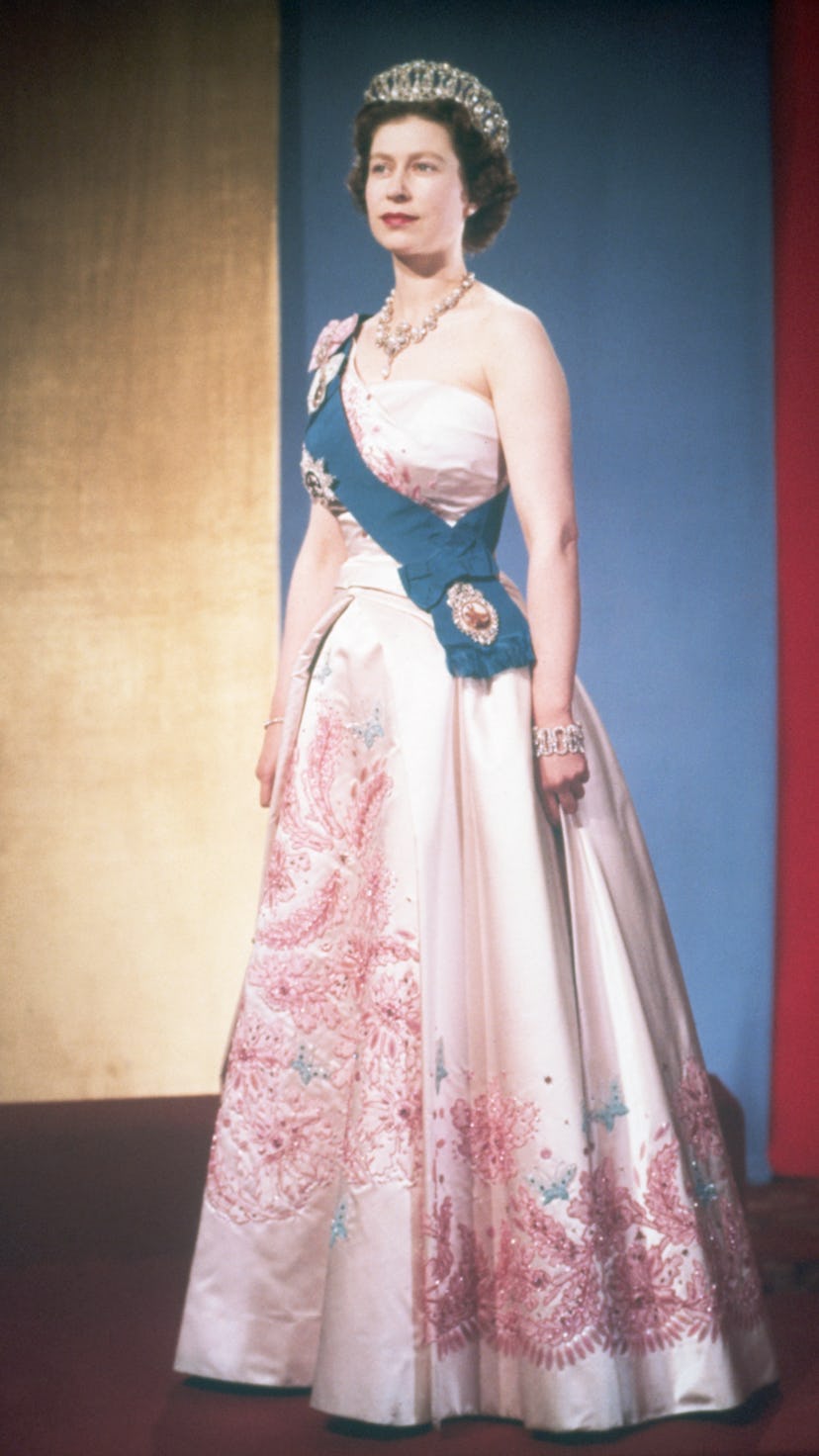 Queen Elizabeth II wearing the crown jewels, dressed for a formal occasion. She wears her family's o...