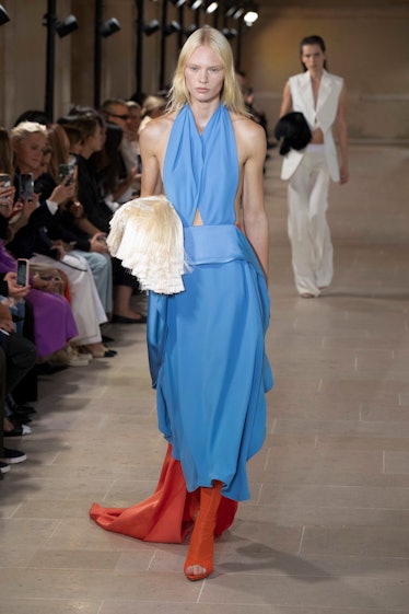 A model in Victoria Beckham maxi sky blue and orange dress and orange boots at Paris Fashion Week Sp...