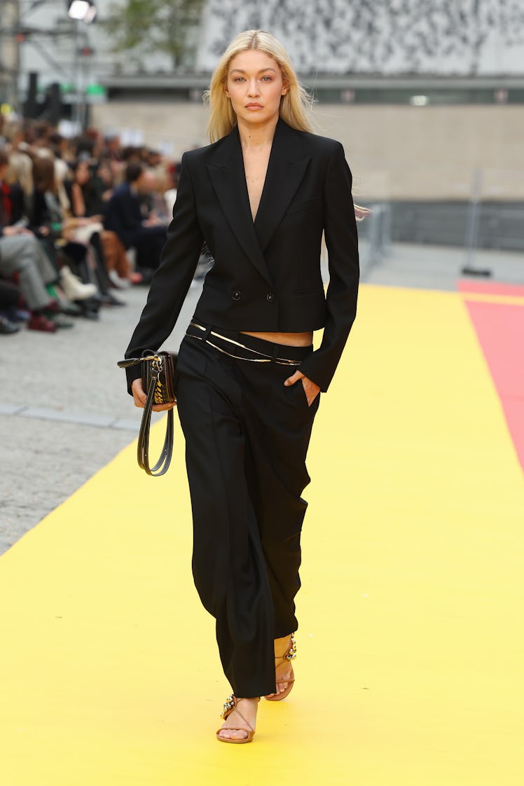 Gigi Hadid wearing Stella McCartney’s black blazer and long trousers at Paris Fashion Week Spring 20...
