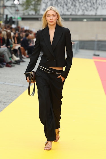 Gigi Hadid wearing Stella McCartney’s black blazer and long trousers at Paris Fashion Week Spring 20...