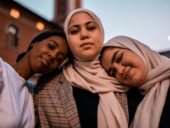 three young women pose for a photo as they all discuss how they will be the most affected by the oct...